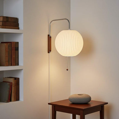 Ribbed globe wall light above a wooden side table