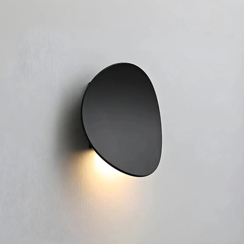 Black pebble wall light with downward glow
