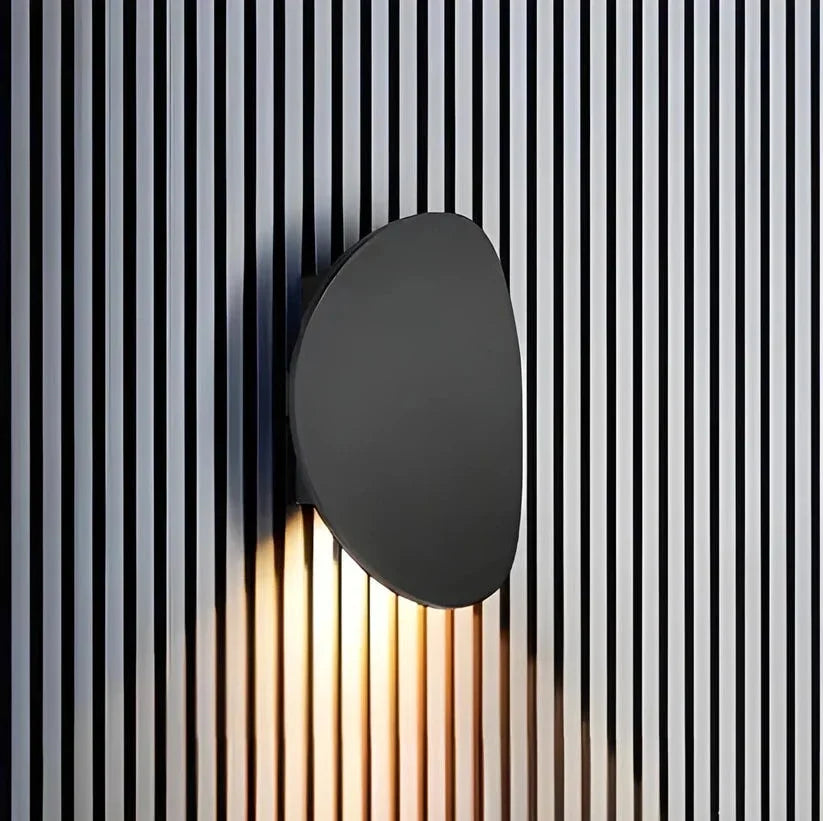 Black pebble wall light on a slatted wall