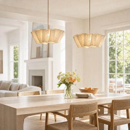 Two pleated fabric pendants above a dining table