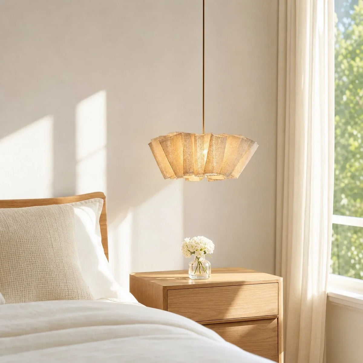 Pleated fabric pendant beside a bed