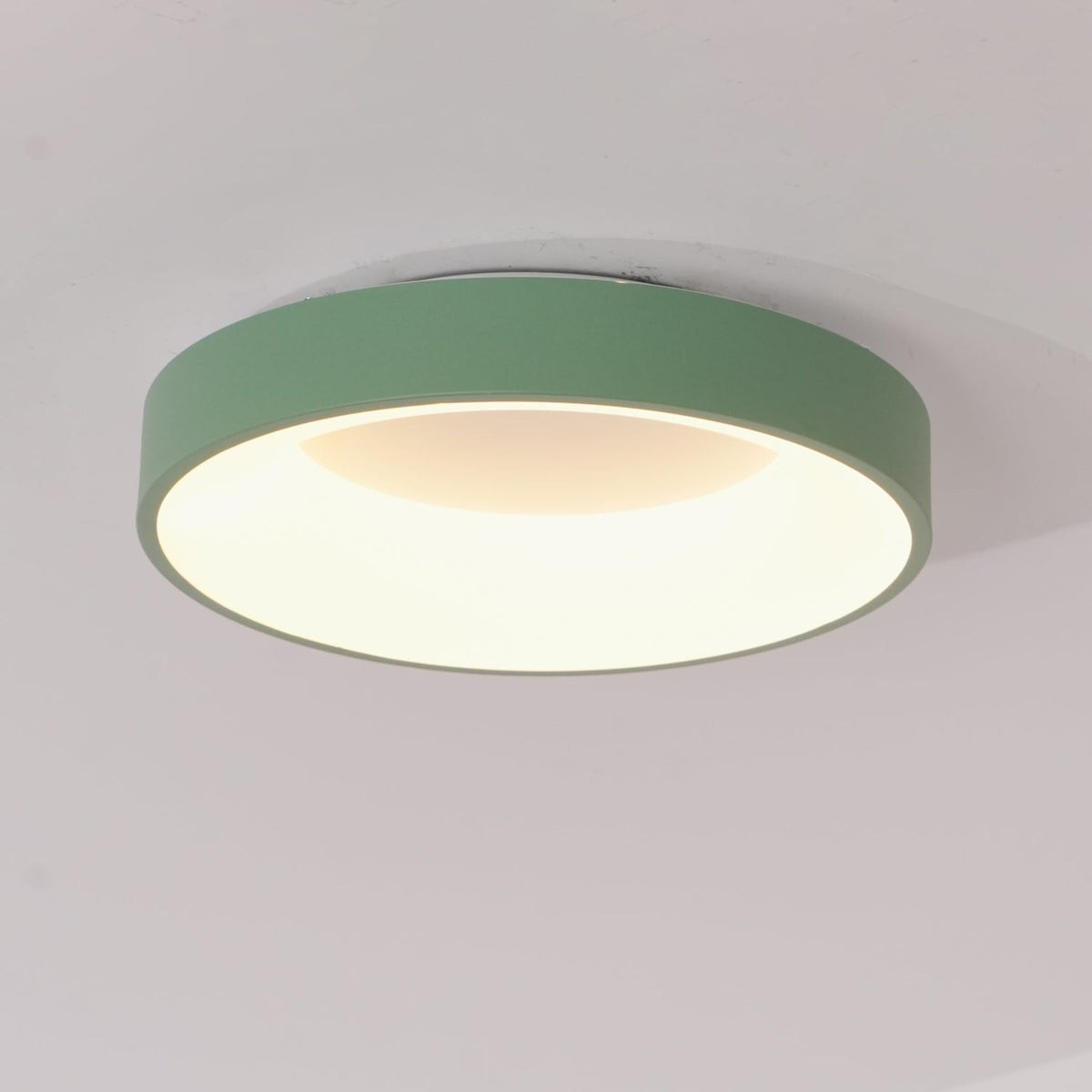 Green recessed-ring LED flush ceiling light mounted on a ceiling