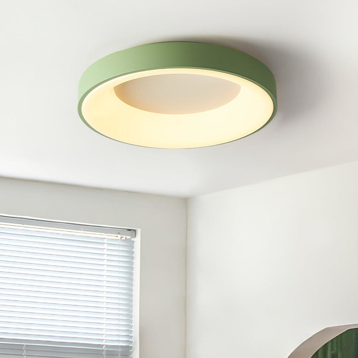Green recessed-ring LED flush ceiling light mounted on a ceiling