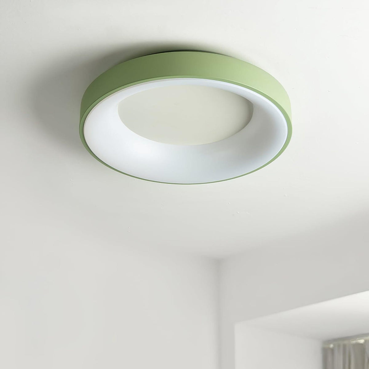Green recessed-ring LED flush ceiling light mounted on a ceiling
