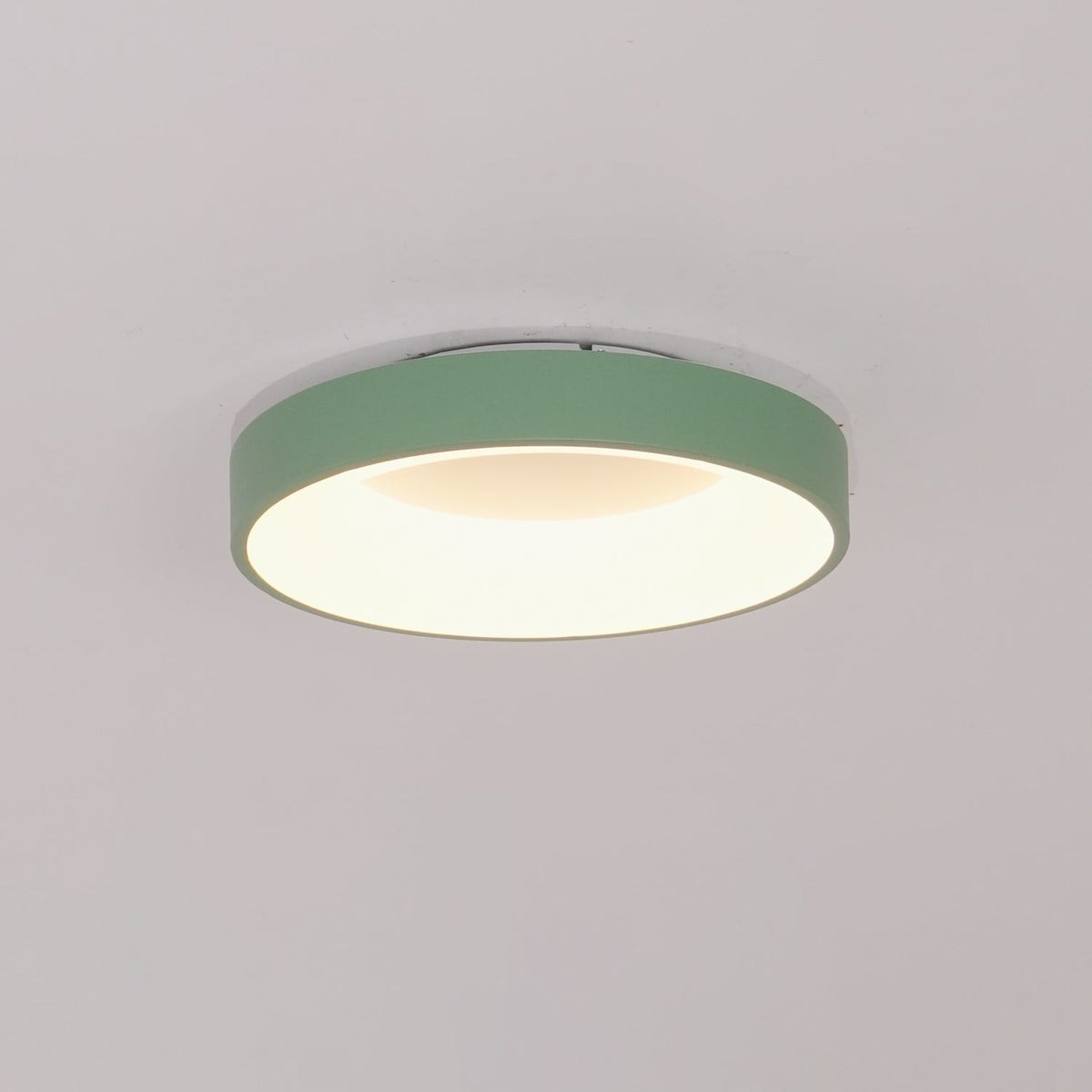 Green recessed-ring LED flush ceiling light mounted on a ceiling