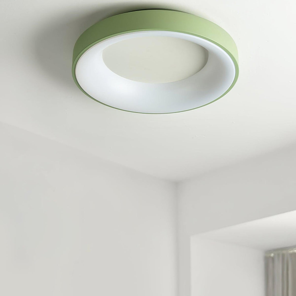 Green recessed-ring LED flush ceiling light mounted on a ceiling