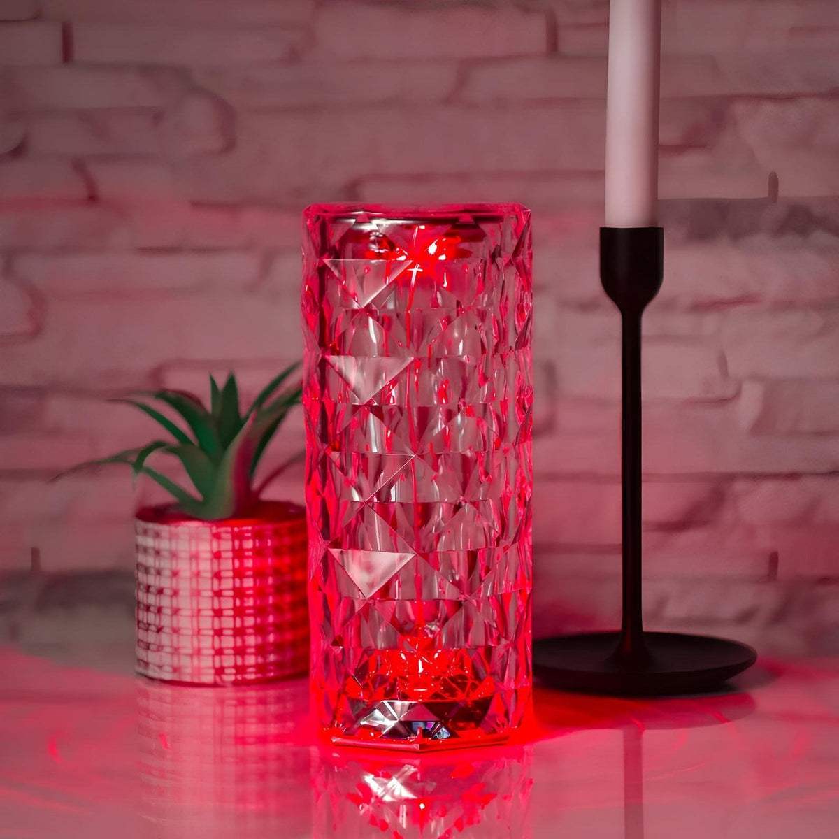 Cylinder table lamp glowing red beside a candlestick