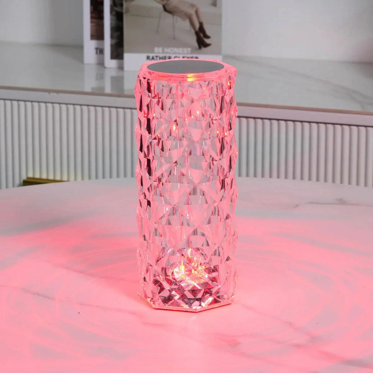 Cylinder table lamp glowing pink on a table