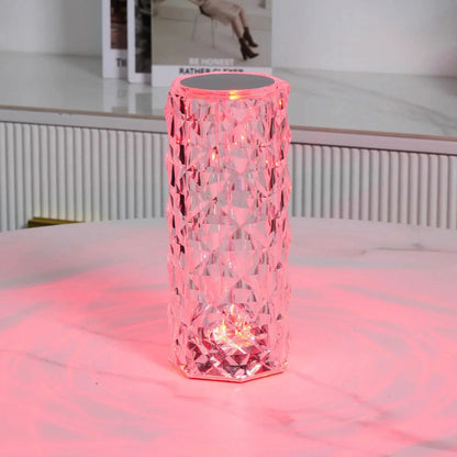 Cylinder table lamp glowing pink on a table