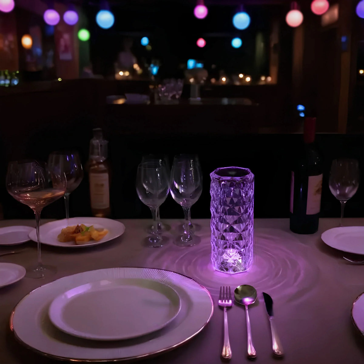 Crystal-effect cylinder lamp glowing purple on a dining table