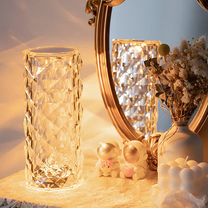 Illuminated crystal-effect cylinder lamp beside a mirror