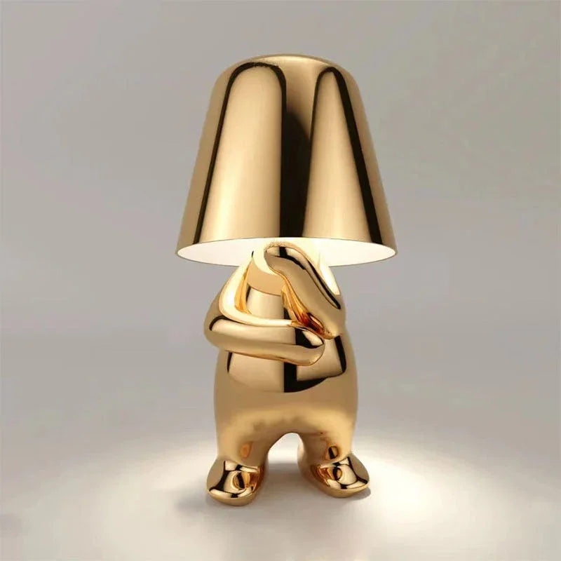 Modern Thoughtful gold rechargeable LED table lamp featuring a minimalist figure design with a polished metallic finish and touch control functionality.