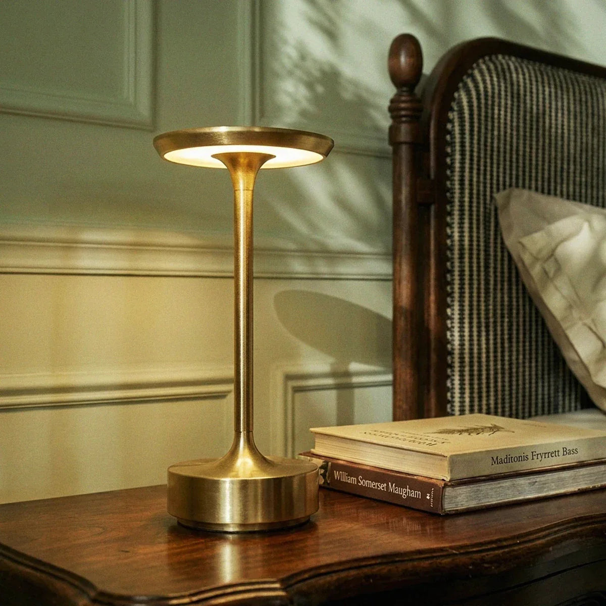 Gold touch-controlled lamp on a bedside table