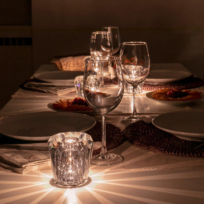 Mini crystal glass lamps casting light patterns on a dining table