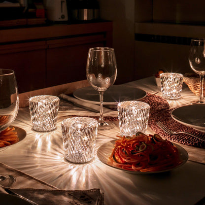 Mini crystal glass lamps casting light patterns on a dining table