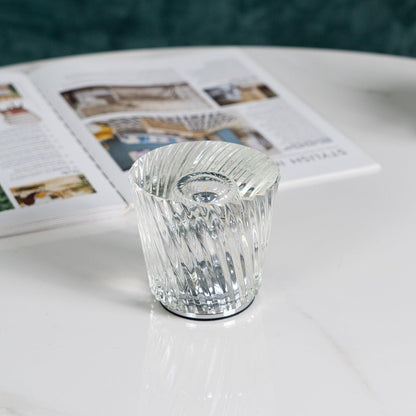 Close-up of spiral-faceted crystal glass table lamp and central LED