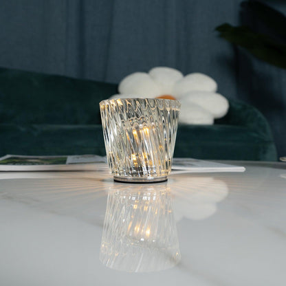 Close-up of spiral-faceted crystal glass table lamp and central LED