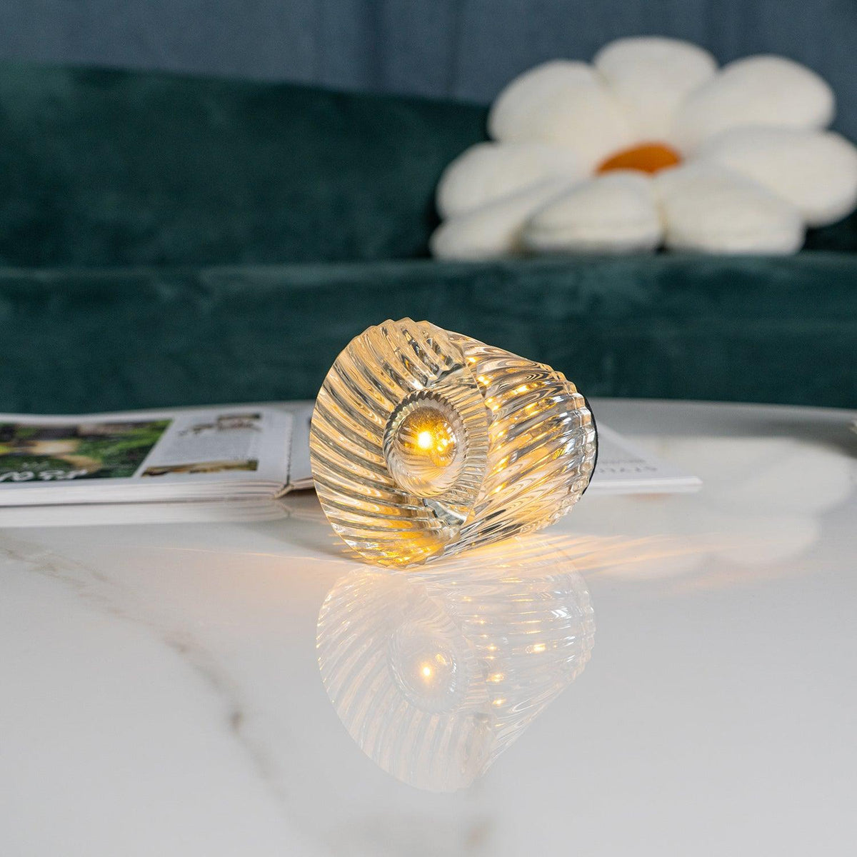 Close-up of spiral-faceted crystal glass table lamp and central LED