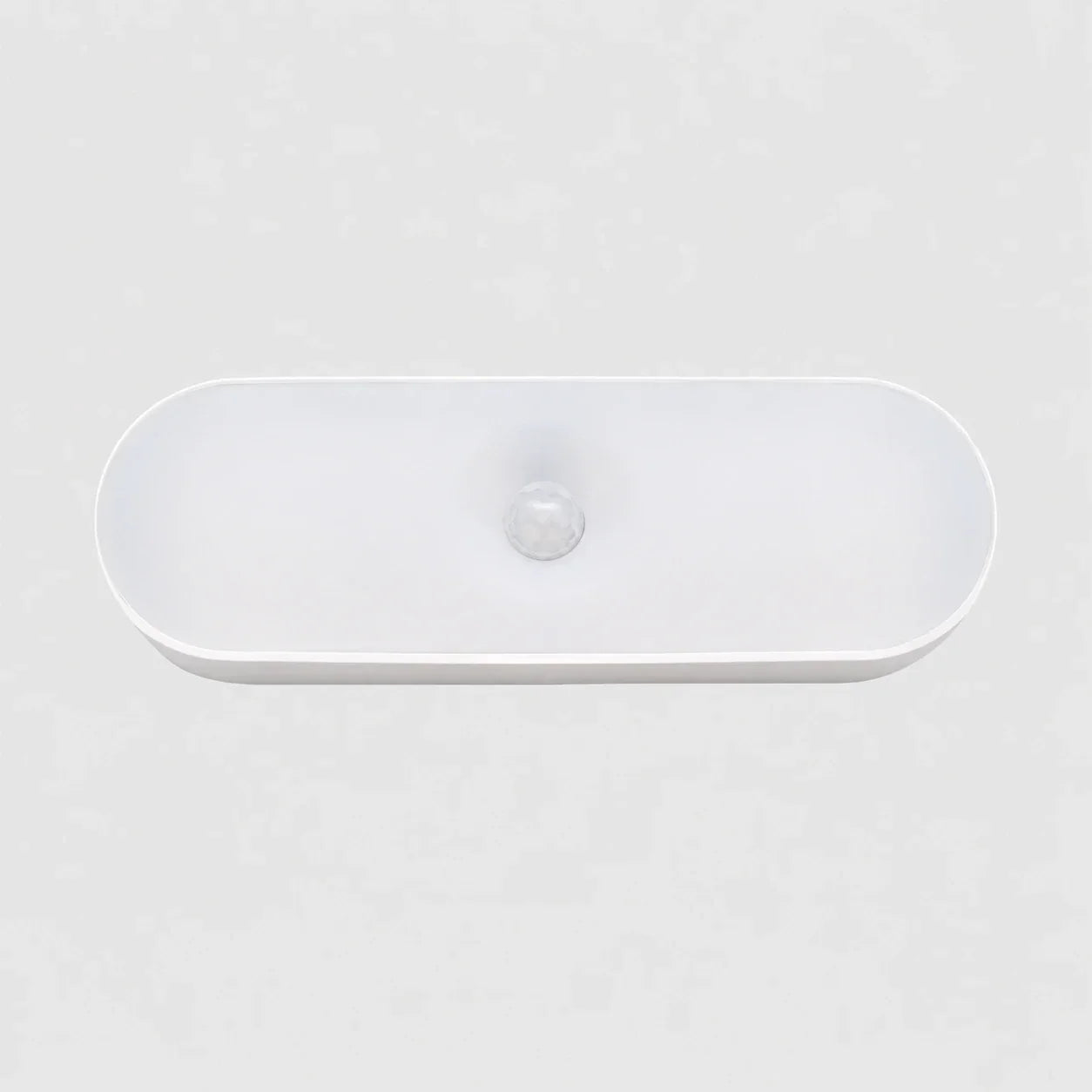 A sleek, white oval rechargeable LED wall light featuring a central motion sensor, designed for convenient indoor lighting in a minimalist style.