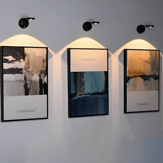 Black motion sensor wall lights illuminating framed pictures
