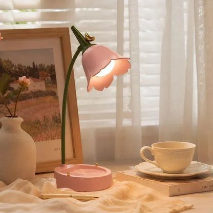 Pink rechargeable flower lamp beside a teacup