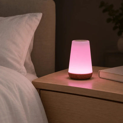 Pink colour-changing night light on a bedside table