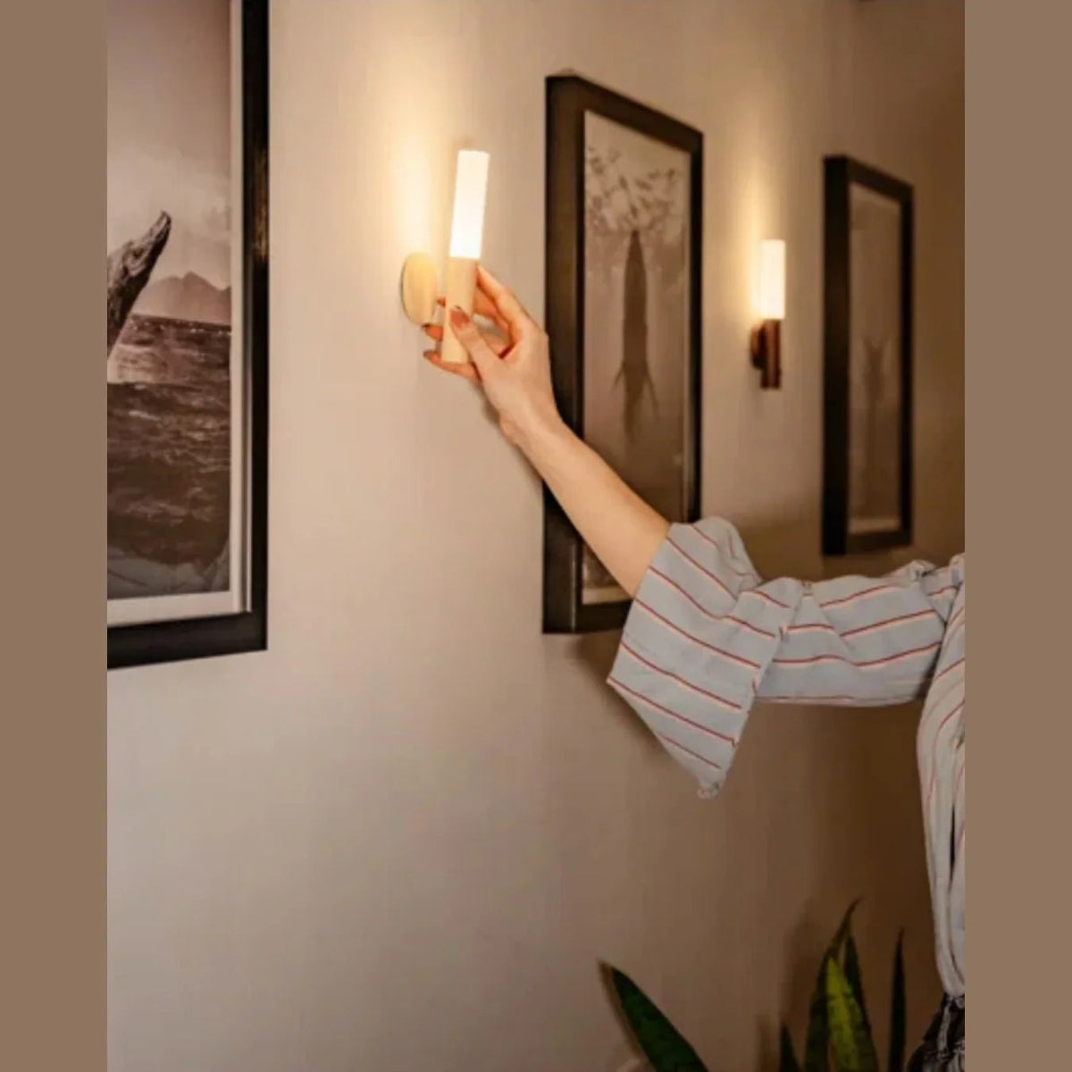 Person lifting a rechargeable light from its wall base
