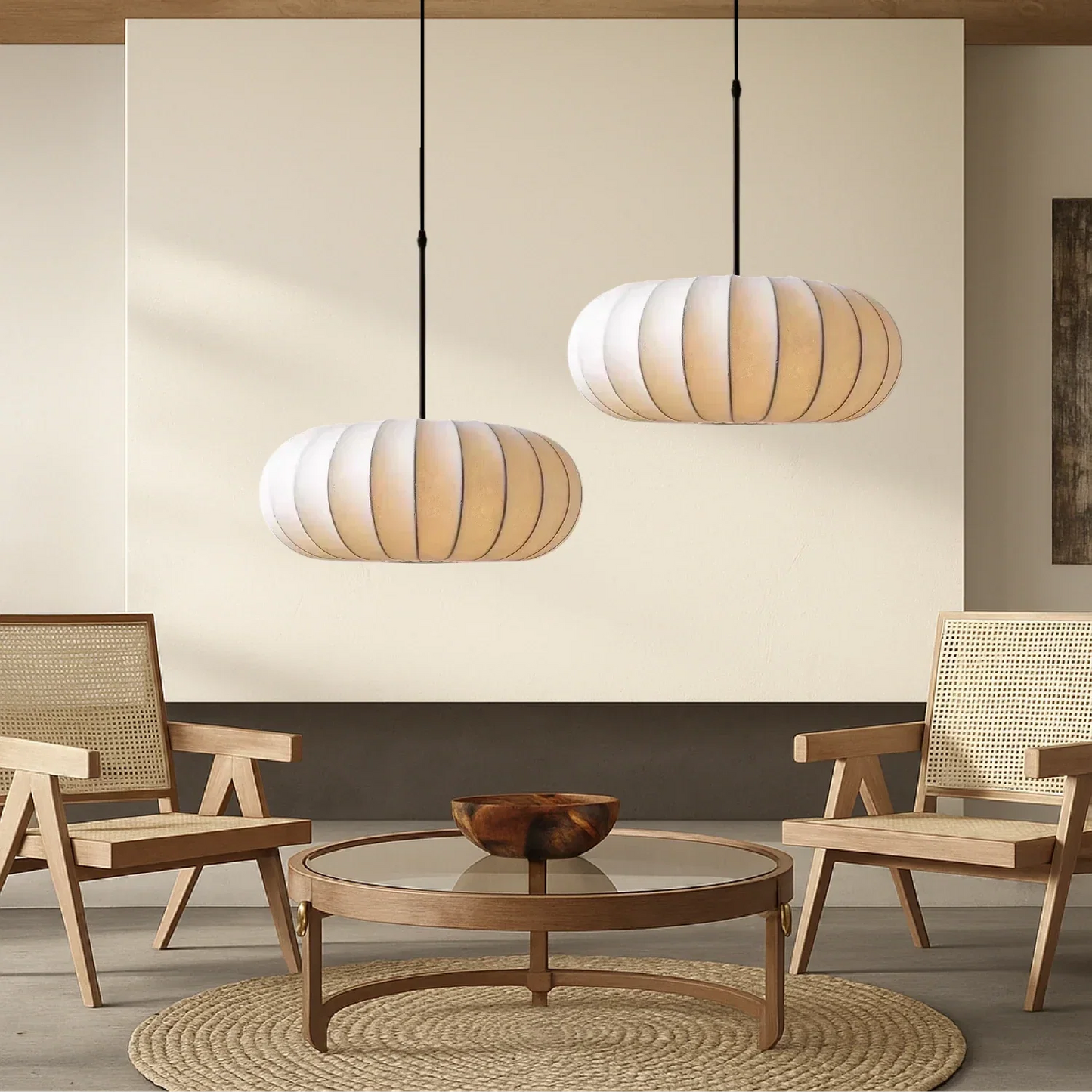 Two retro silk pumpkin pendant lights hanging at different heights in a modern living room with wooden cane chairs and a round coffee table.