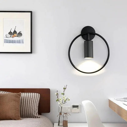 Black ring wall light beside a desk