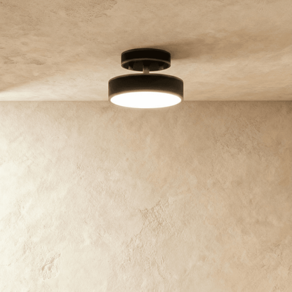 Black round iron semi-flush ceiling light illuminated