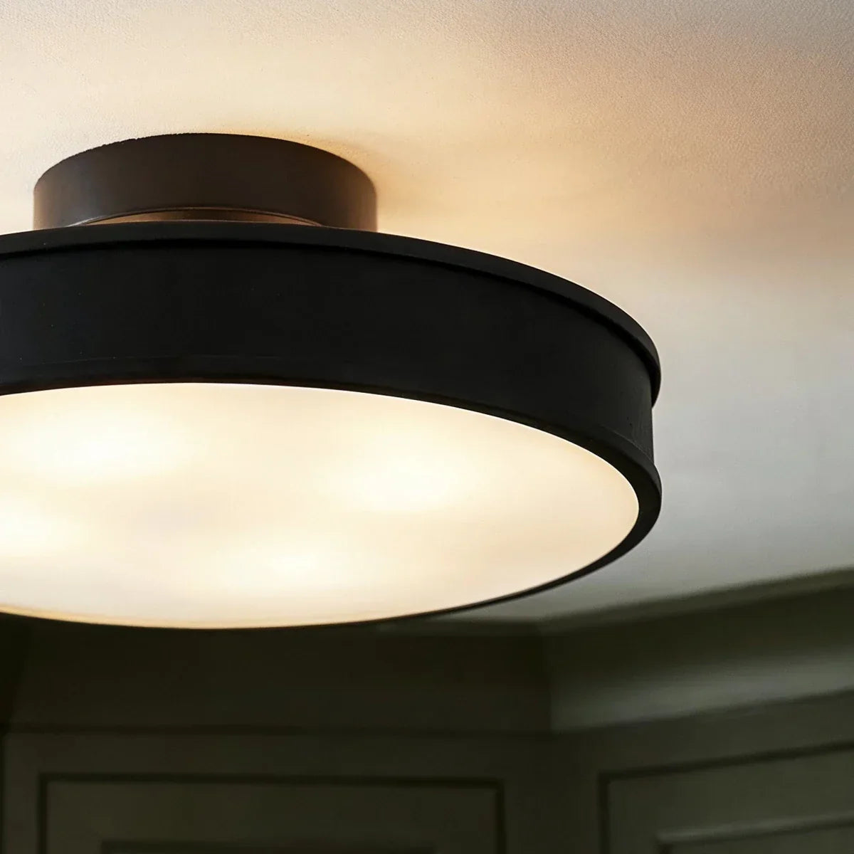 Black round iron ceiling light illuminated diffuser detail