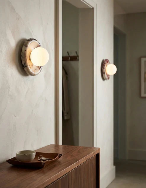 Round stone globe sconces beside a bathroom mirror