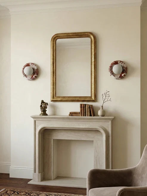 Round marble wall sconces beside a fireplace