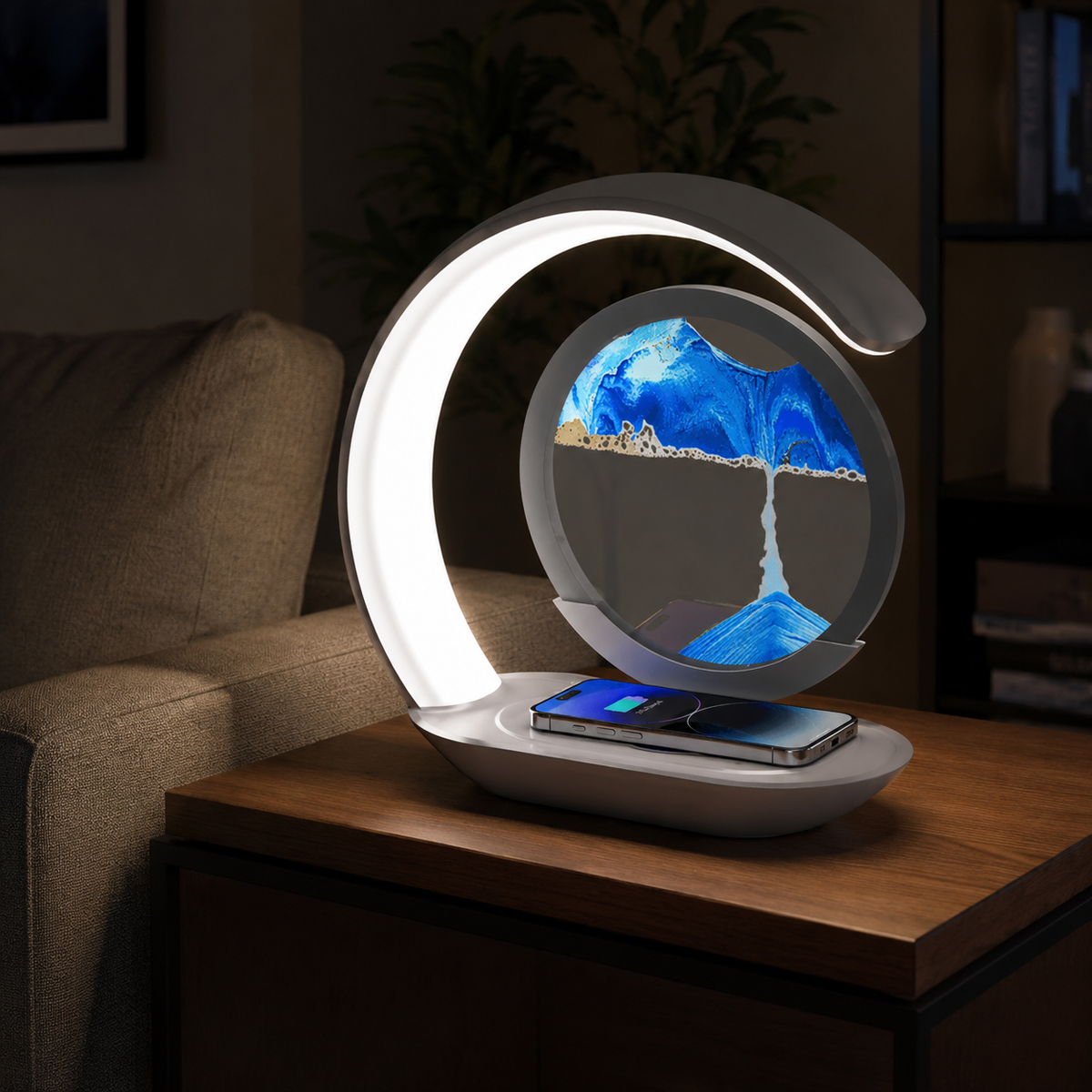 Blue sandscape lamp and phone charger beside a bed