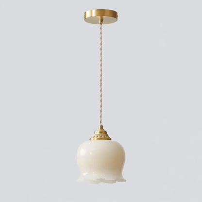 Cream scalloped floral pendant light with a vintage-style brass ceiling rose and a twisted fabric cable, perfect for elegant bedroom or kitchen lighting.