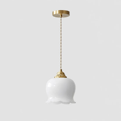 A white glass pendant light featuring a scalloped floral-shaped shade, suspended from a brass ceiling rose by a twisted gold-coloured cord.