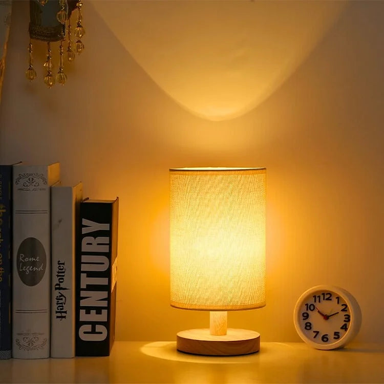 Scandinavian linen-shade table lamp beside a clock