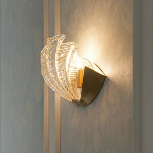 Layered glass shell sconce casting warm light