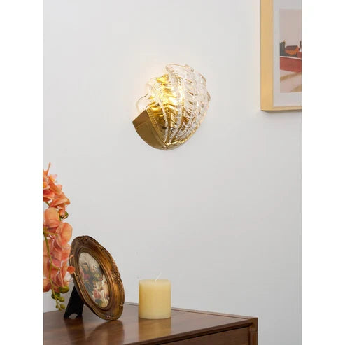 Illuminated clear shell sconce above a sideboard