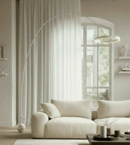White arc floor lamp beside a sofa