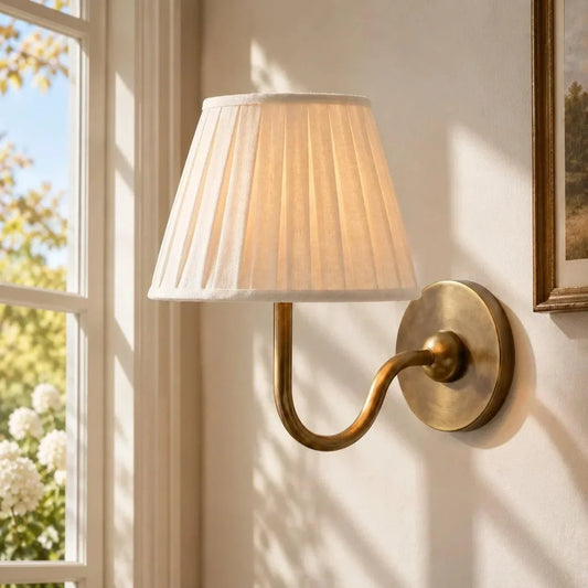 Brass single-arm wall light with a pleated shade