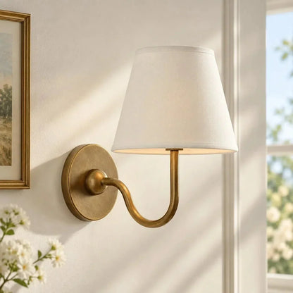 Brass single-arm wall light with a plain shade