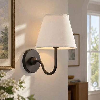 Bronze single-arm wall light with a plain shade