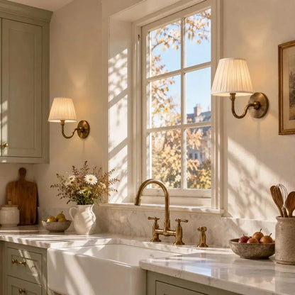 Traditional brass wall lights beside a kitchen window