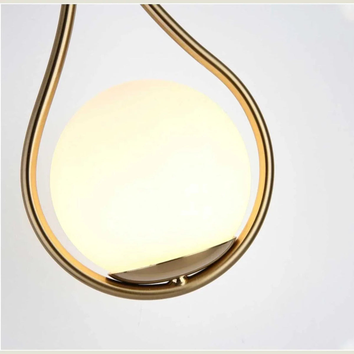 Close-up of opal globe in gold teardrop frame