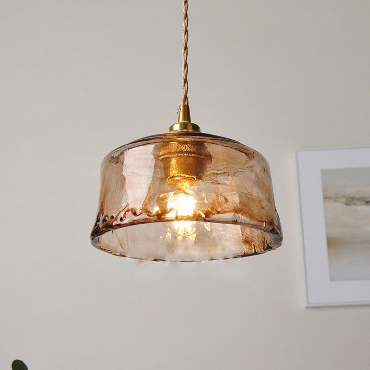 Textured glass pendant light with brass fitting and warm bulb