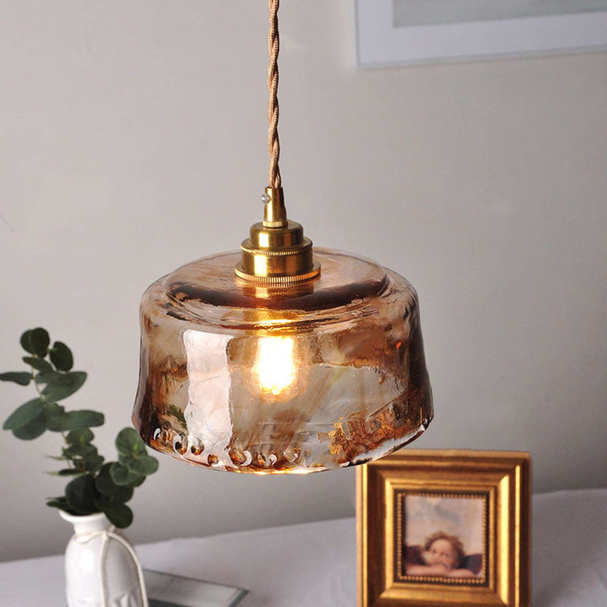 Textured glass pendant above a sideboard