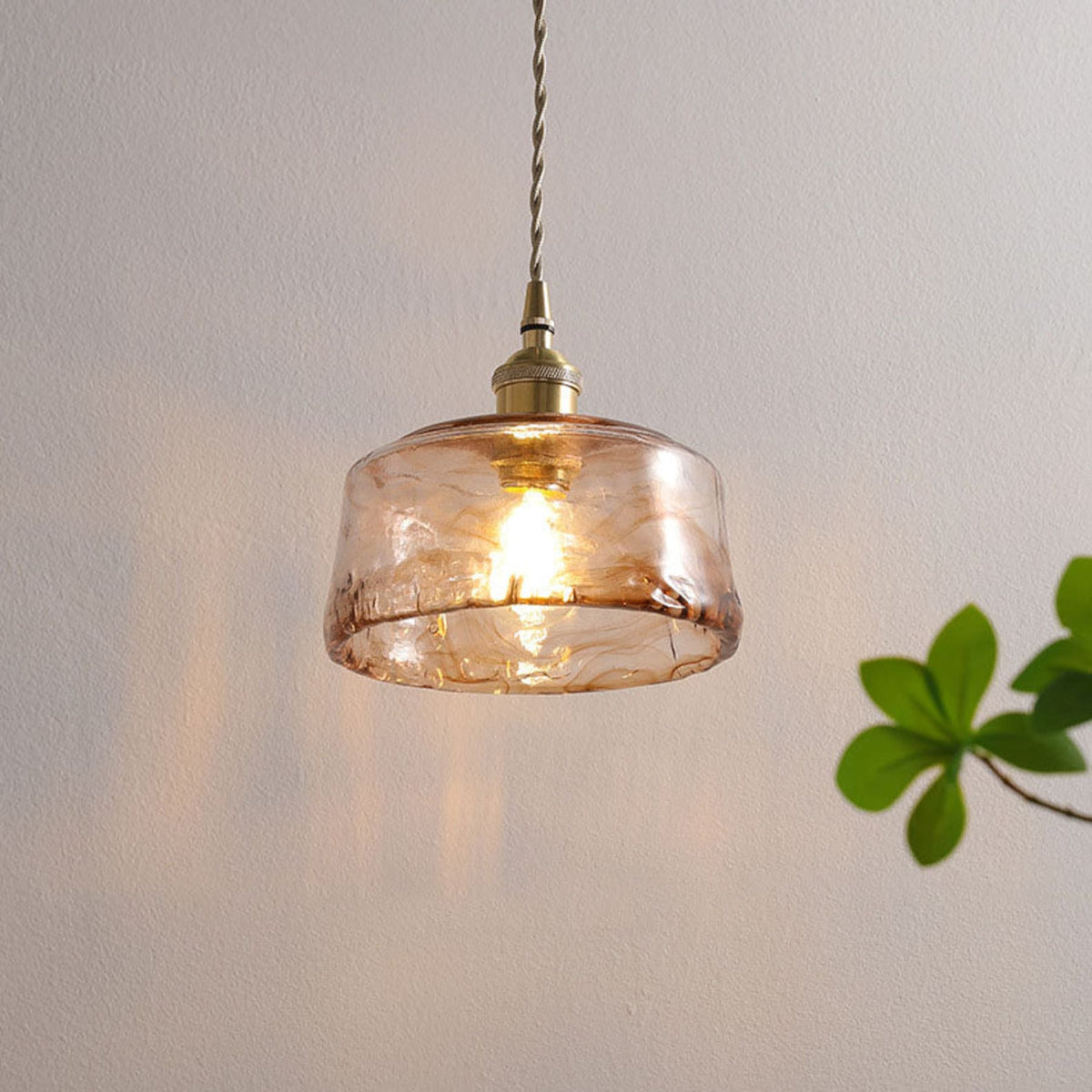 Glass pendant light beside a houseplant