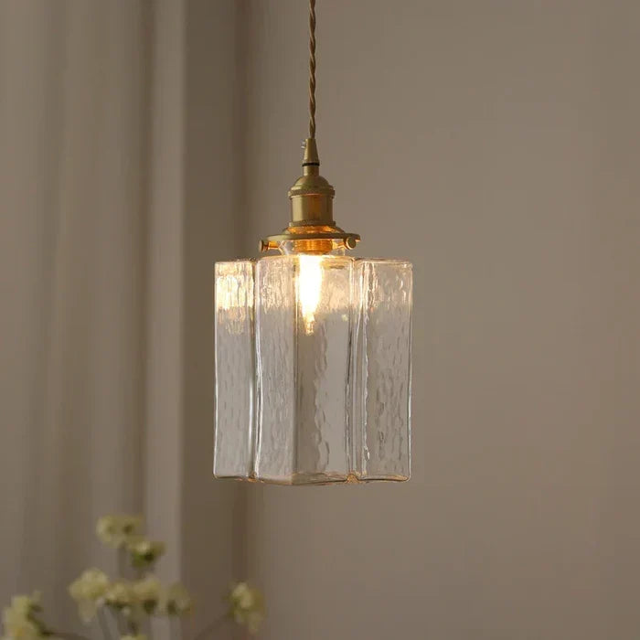 Illuminated tall glass pendant with brass-finish fitting