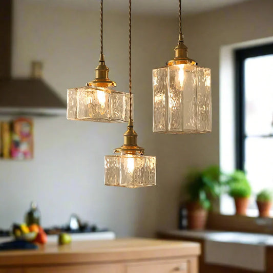 Textured glass pendants hanging at different heights by a window